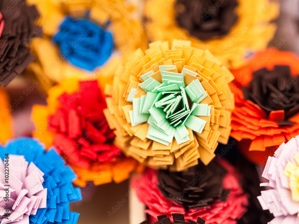 Small, colorful paper flowers made with quilling technique