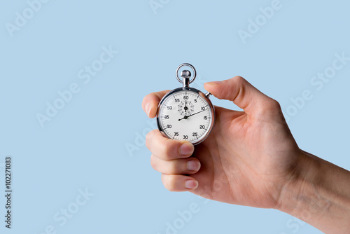 timer held in hand, blue background photo
