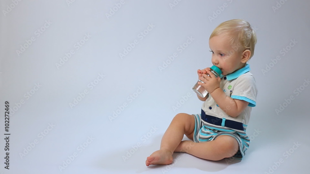 Caucasian child, little baby kid toddler boy sits and drinks on white background. Childhood dreams and memories. Caucasian child, little baby kid toddler boy sits and drinks on white background. Childhood dreams and memories.