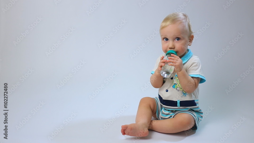 Caucasian child, little baby kid toddler boy sits and drinks on white background. Childhood dreams and memories. Caucasian child, little baby kid toddler boy sits and drinks on white background. Childhood dreams and memories.