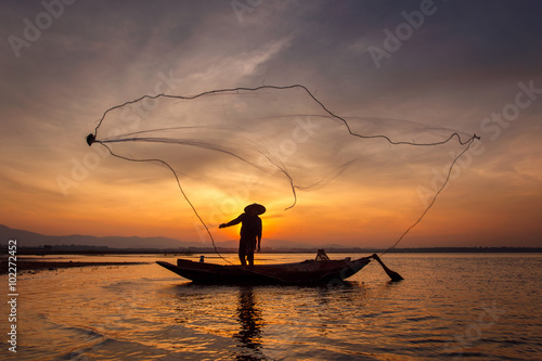 Silhouette of traditional fishermen throwing net fishing inle la