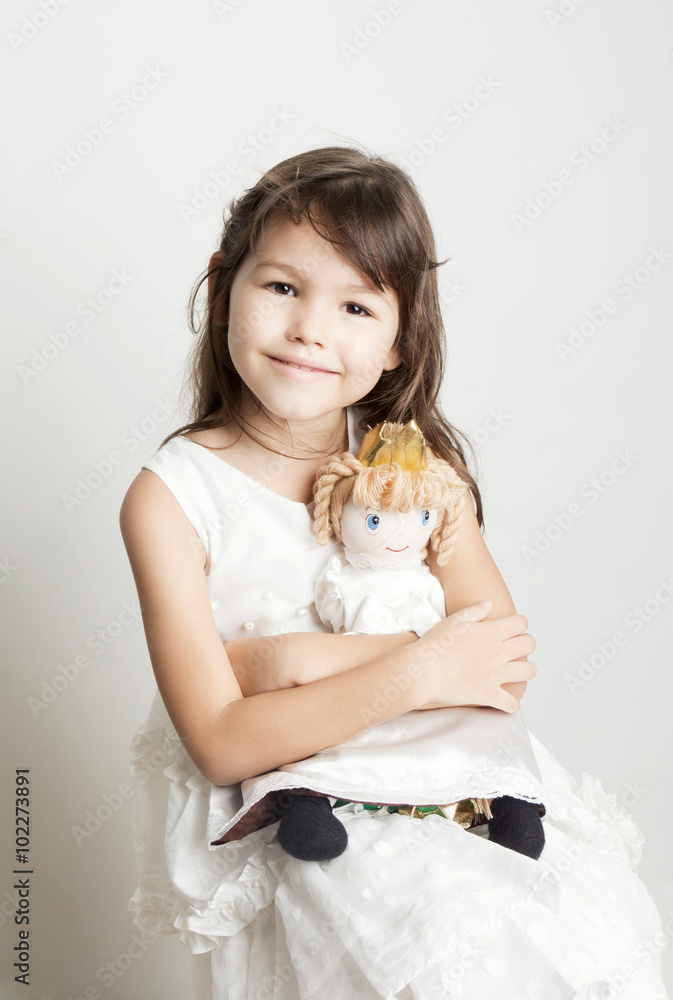 Adorable little girl cuddles and plays with her doll Adorable little girl cuddles and plays with her doll