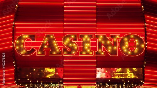 The word casino is lit up in neon lights at night on Freemont Street in Las Vegas