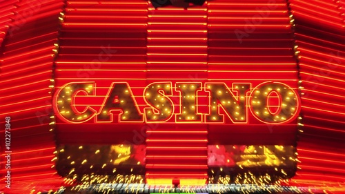 The word casino is lit up in neon lights at night on Freemont Street in Las Vegas