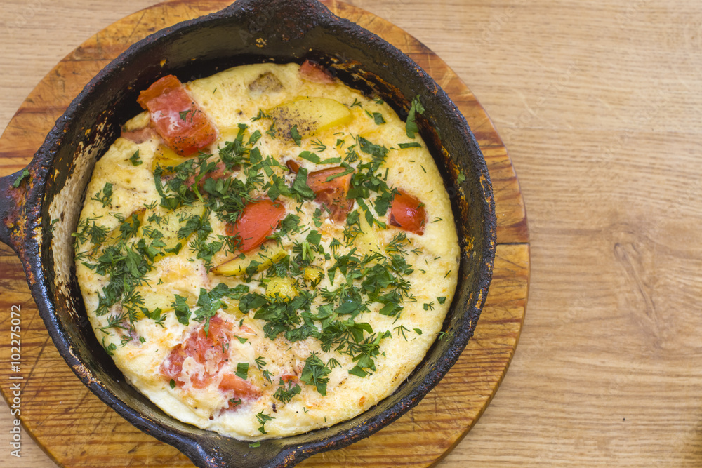 Frittata (italian omelet) with cherry tomatoes and spinach in pa