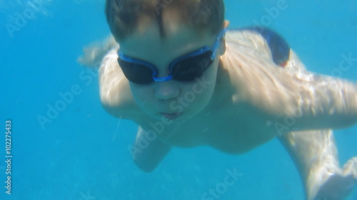 Child teen boy swims and dives in the sea. Underwater footage
