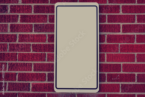 Red brick wall with blank sign