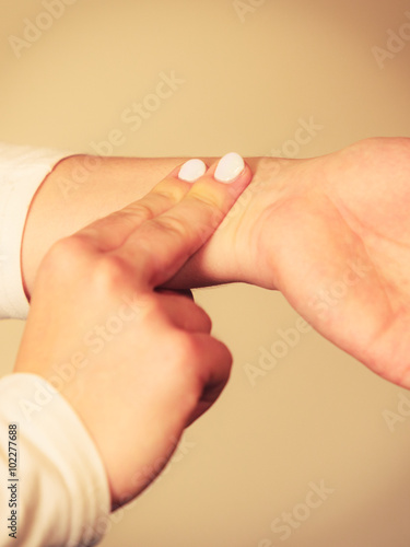 Woman checking pulse on wrist closeup