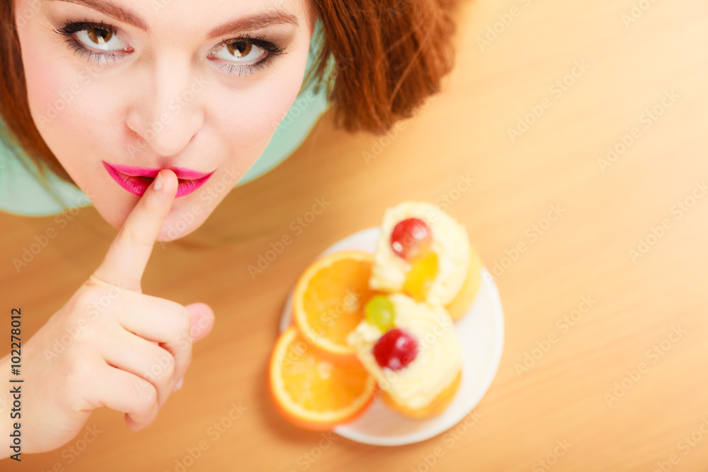 Woman eating cake showing quiet sign. Gluttony. Woman eating cake showing quiet sign. Gluttony.