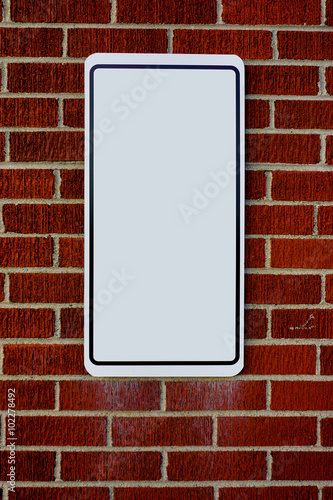 Red brick wall with blank sign
