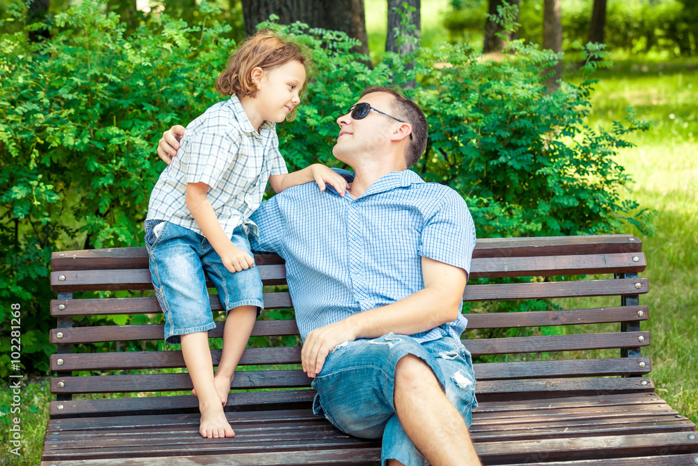Father and son playing at the park on bench at the day time. Father and son playing at the park on bench at the day time.