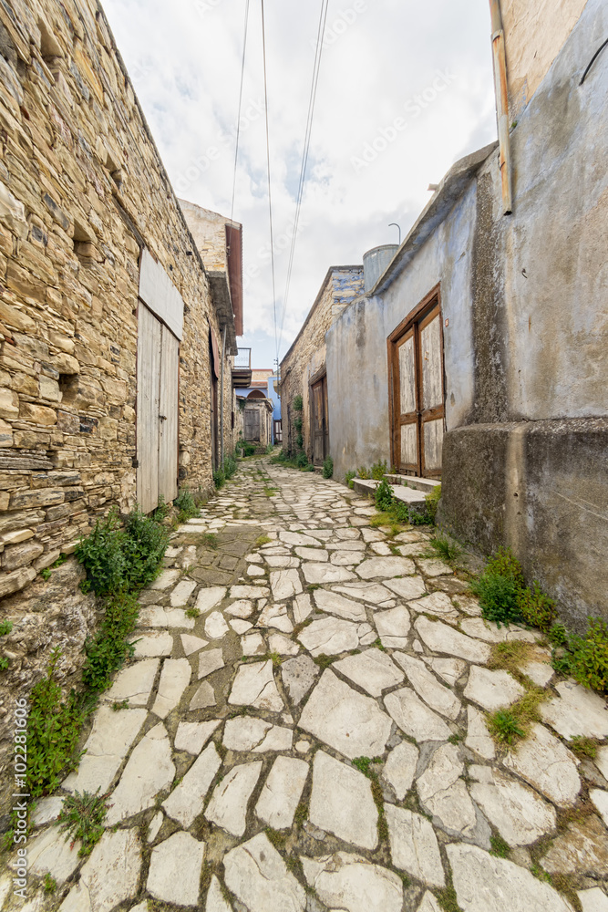 Fisheye view on vanishing medieval narrow pavement street passage with stonemasonry building. Pano Lefkara, Cyprus.
