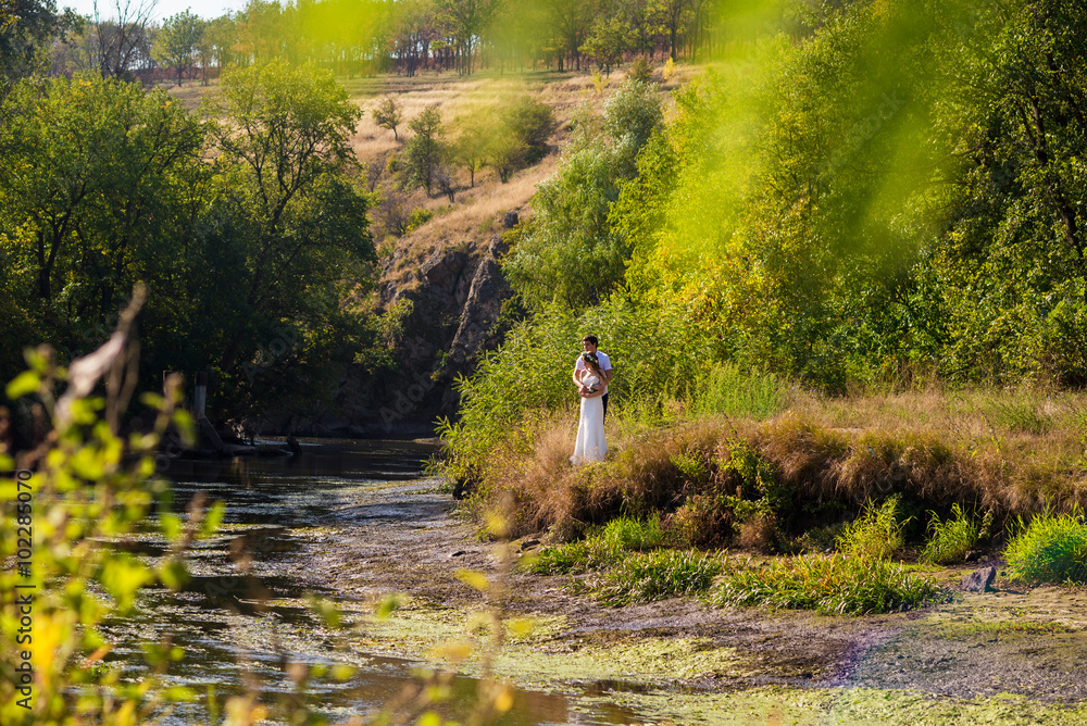 Obraz premium Bride and groom walk in the park