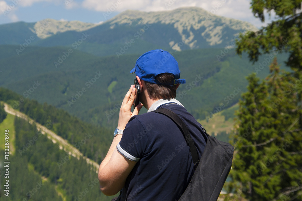 Tourist in the mountains talking on mobile phone