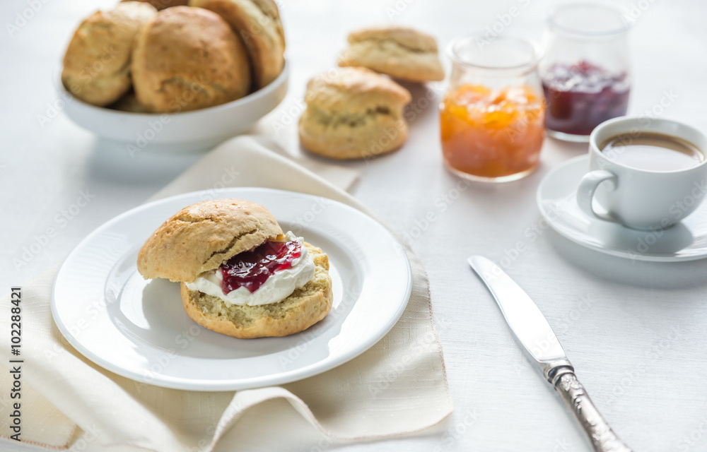 Scones with cream and fruit jam and cup of coffee Scones with cream and fruit jam and cup of coffee