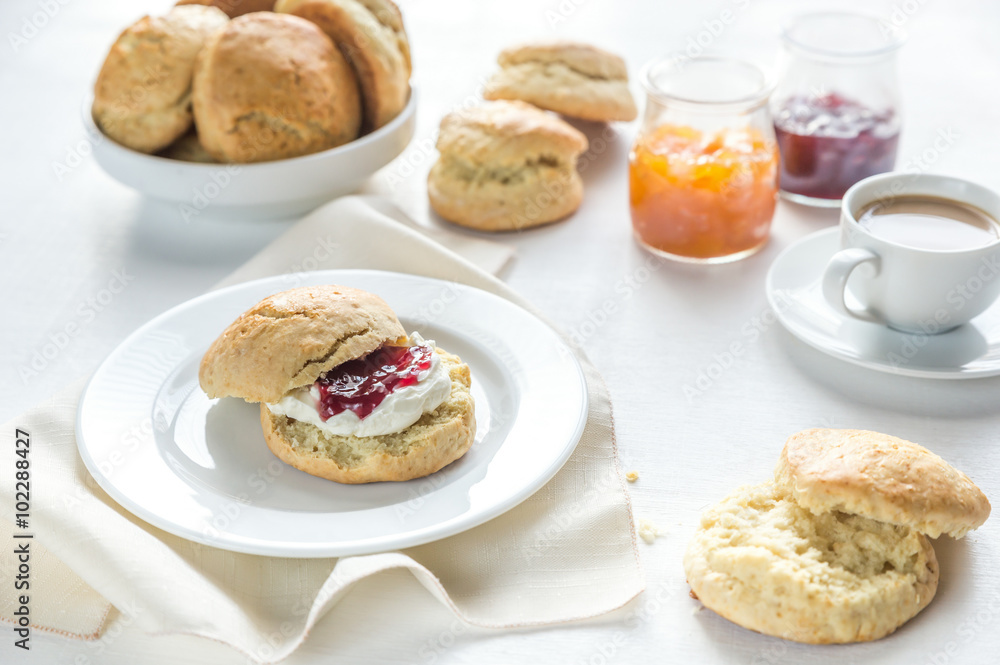 Scones with cream and fruit jam and cup of coffee Scones with cream and fruit jam and cup of coffee