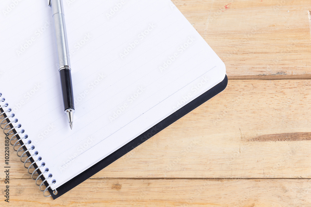 Blank white notebook with pen on wood desk. shallow depth of field Blank white notebook with pen on wood desk. shallow depth of field
