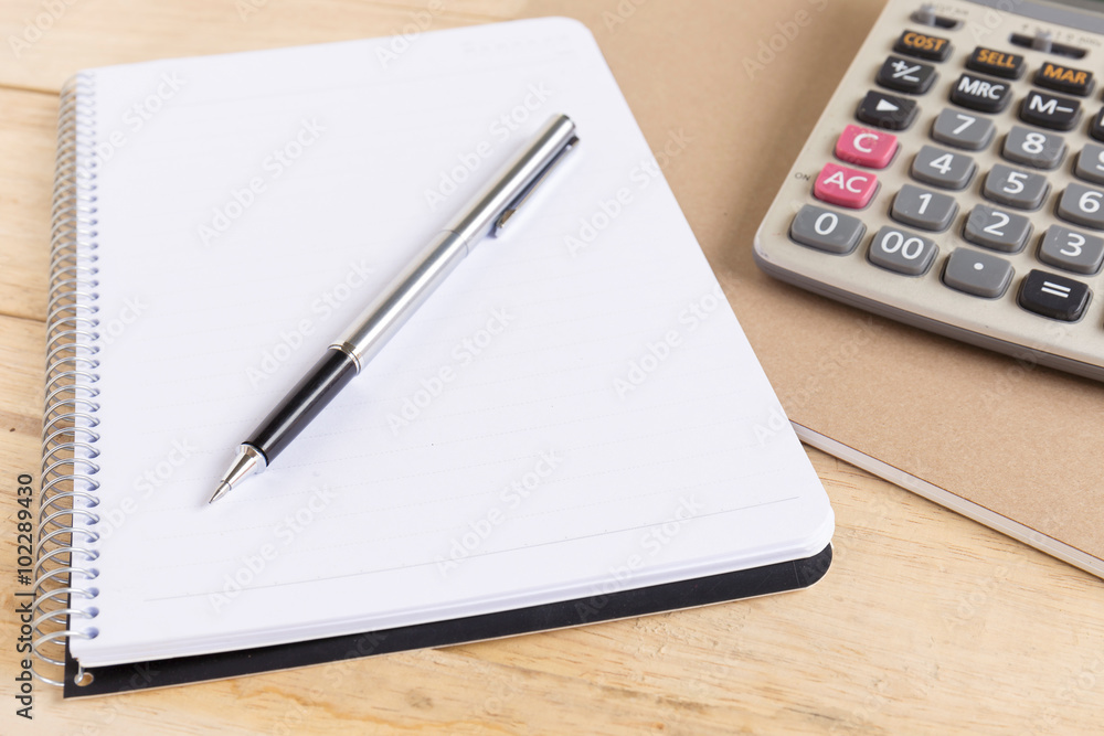 Blank white notebook with pen on wood desk. shallow depth of field Blank white notebook with pen on wood desk. shallow depth of field