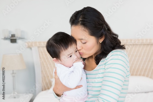 Lovely mother carrying baby daughter