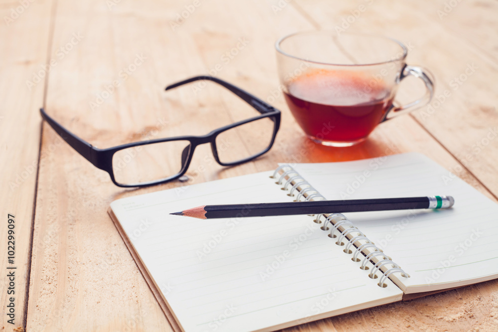 tea in glass and notebook,pencil with glasses on wood tea in glass and notebook,pencil with glasses on wood
