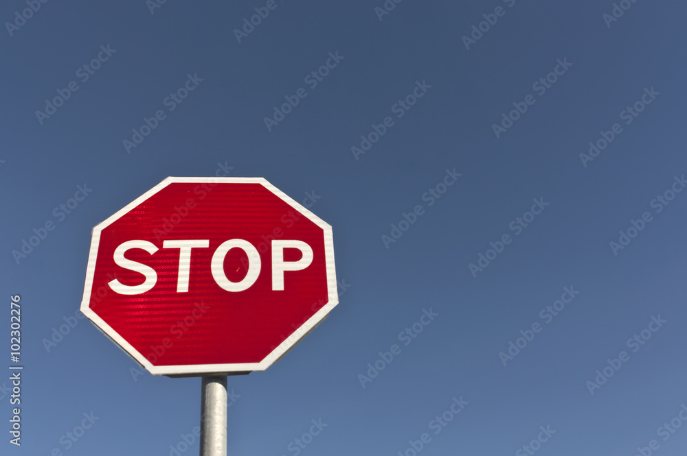 Red stop sign and blue sky.