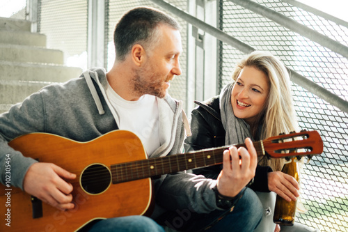 Young beautiful couple  playing guitar