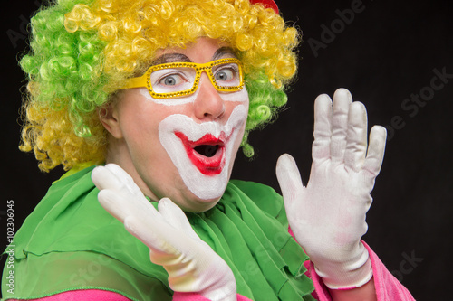 Funny curly clown in shiny glasses with good cheerful emotions