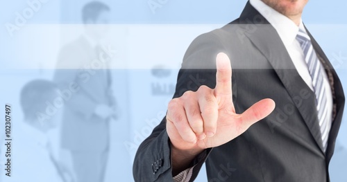 Composite image of businessman pointing with his finger