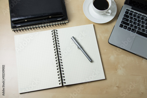 Working desk with coffee laptop glasses book notepad supplies and tablet  on wooden desk