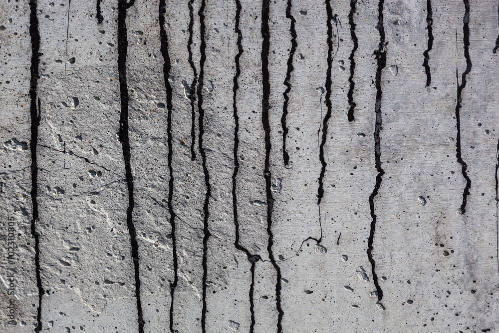 Obraz premium Grey concrete surface with black bitumen streaks