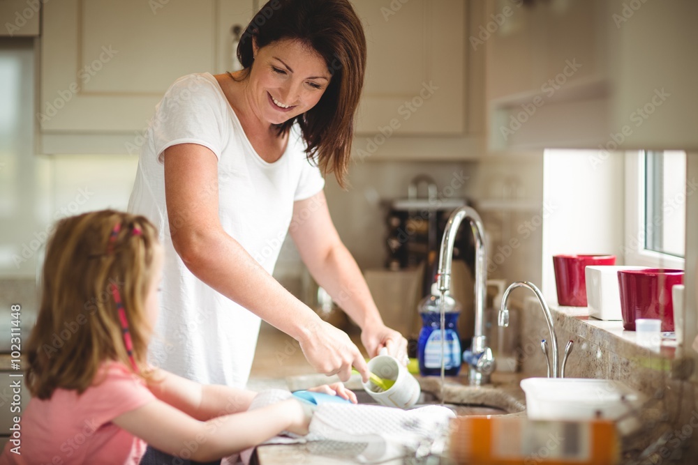 Mother and daughter washing the dishes Mother and daughter washing the dishes
