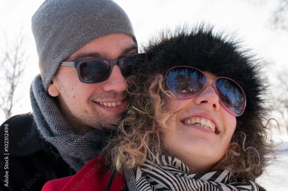 Man embracing young woman enjoying in beautiful sunny winter day Outdoors. Snow. Winter Vacation. Man embracing young woman enjoying in beautiful sunny winter day Outdoors. Snow. Winter Vacation.