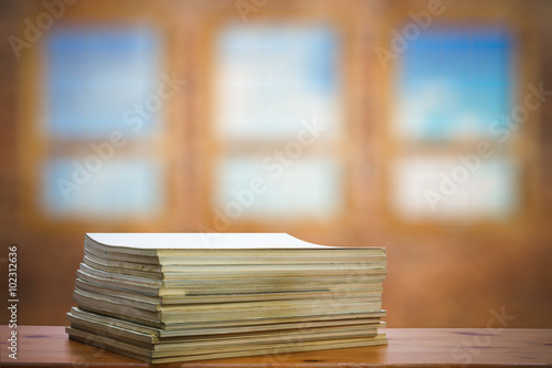 stack of old magazines on wooden table