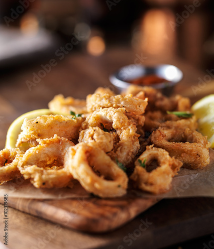 crispy fried calamari rings with marinara dipping sauce and lemon photo