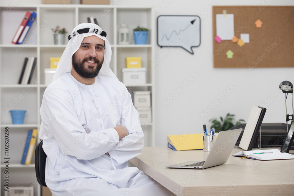 Young happy Arabic business man working on computer in his office Young happy Arabic business man working on computer in his office