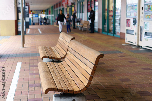 Wallpaper Mural An empty wooden sidewalk bench infort of shopping store Torontodigital.ca