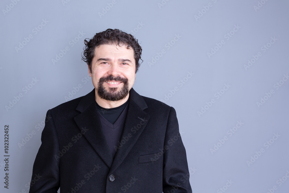 Smiling man in black jacket over gray background Smiling man in black jacket over gray background