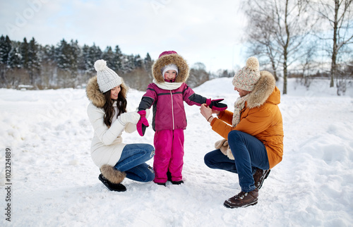 happy family with child in winter clothes outdoors