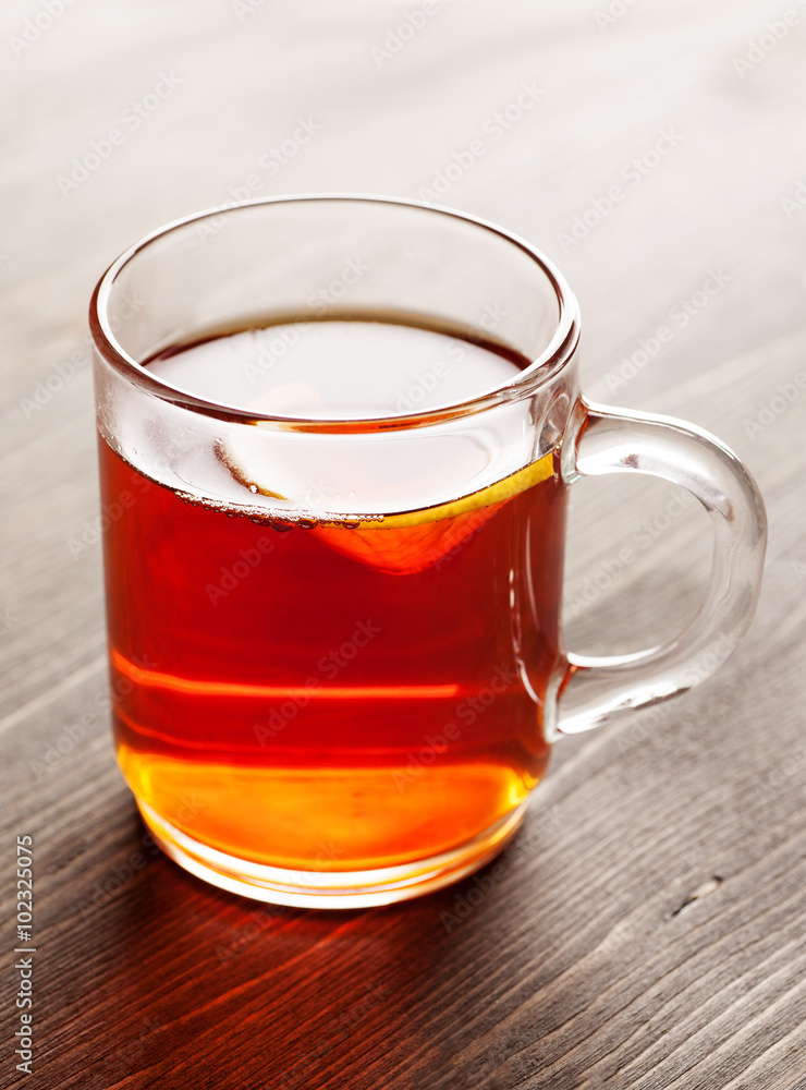 Tea with lemon in glass mug on wooden table Tea with lemon in glass mug on wooden table