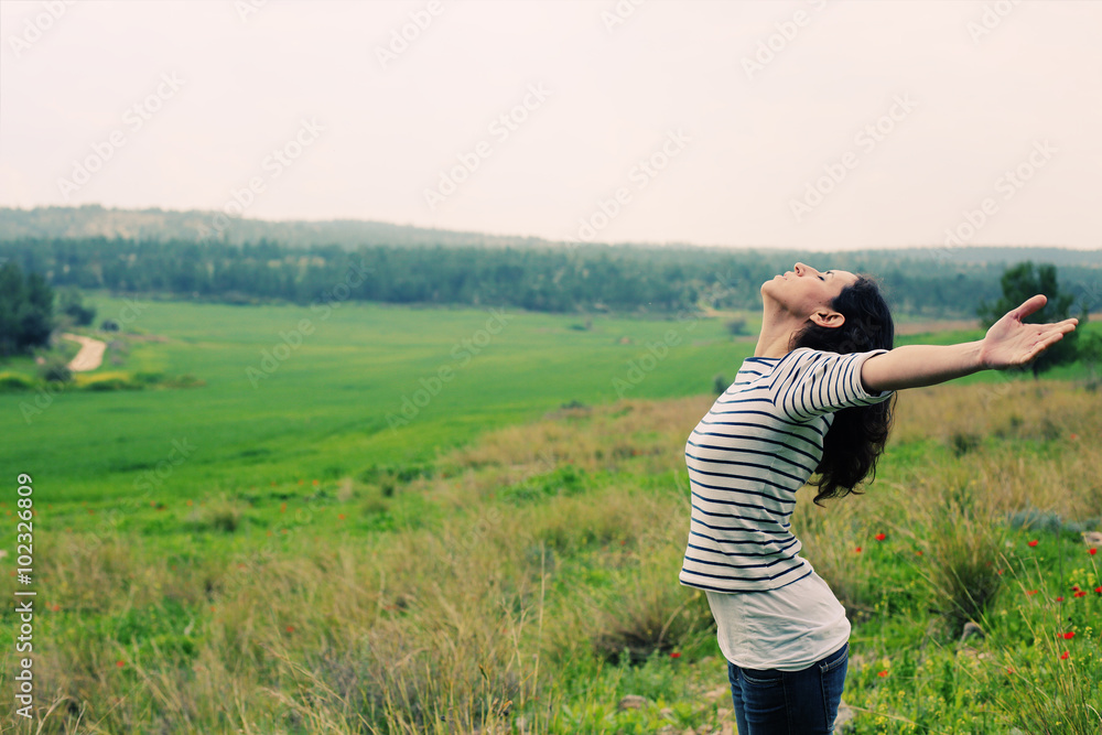 Woman with open arms standing outdoors Woman with open arms standing outdoors