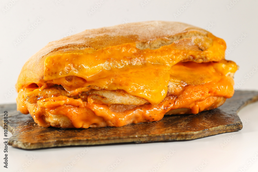 Tasty chicken steak sandwich in a ciabatta with cheddar cheese and thick romanian garlic sauce Tasty chicken steak sandwich in a ciabatta with cheddar cheese and thick romanian garlic sauce