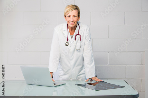 woman doctor standing behind desk