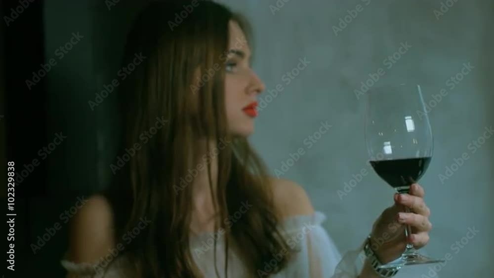 Young attractive Caucasian female holding a glass of red wine Young attractive Caucasian female holding a glass of red wine