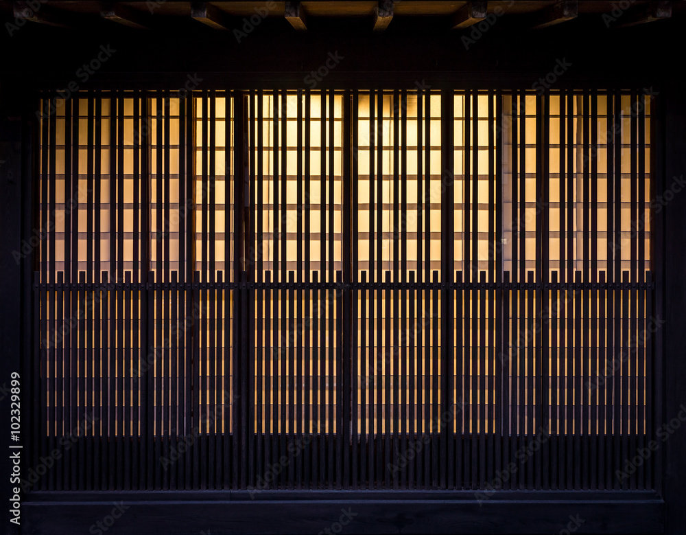 Fototapeta premium Lath wooden wall with background incandescent light. Pattern of vintage wall in Japan.