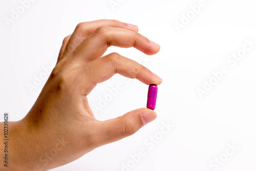 fingers holding a pill