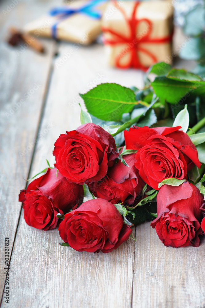 Colorful flower bouquet from red roses and gift boxes Colorful flower bouquet from red roses and gift boxes