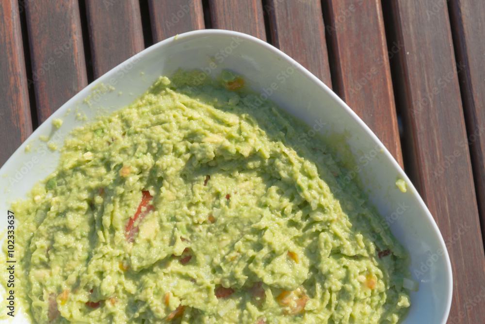 Aerial view closeup of homemade spicy guacamole dip served in bo Aerial view closeup of homemade spicy guacamole dip served in bo
