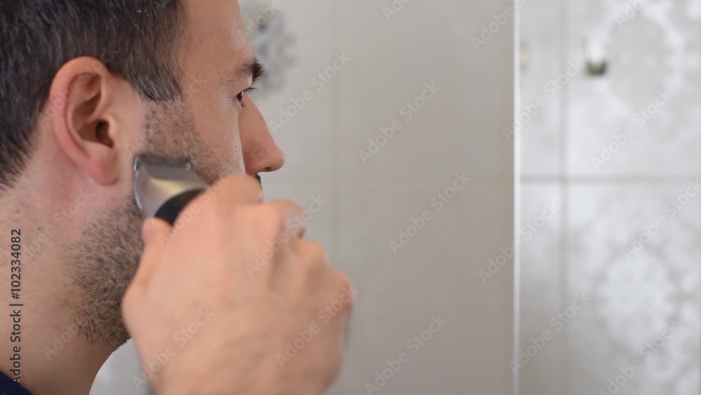 Man Trimming Beard on Mirror in Bathroom Man Trimming Beard on Mirror in Bathroom