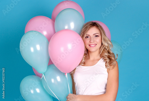 Young beautiful blonde woman with balloons in the studio. Woman holding balloons. Birthday.