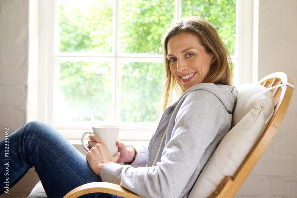 Smiling older woman relaxing at home with cup of tea Smiling older woman relaxing at home with cup of tea